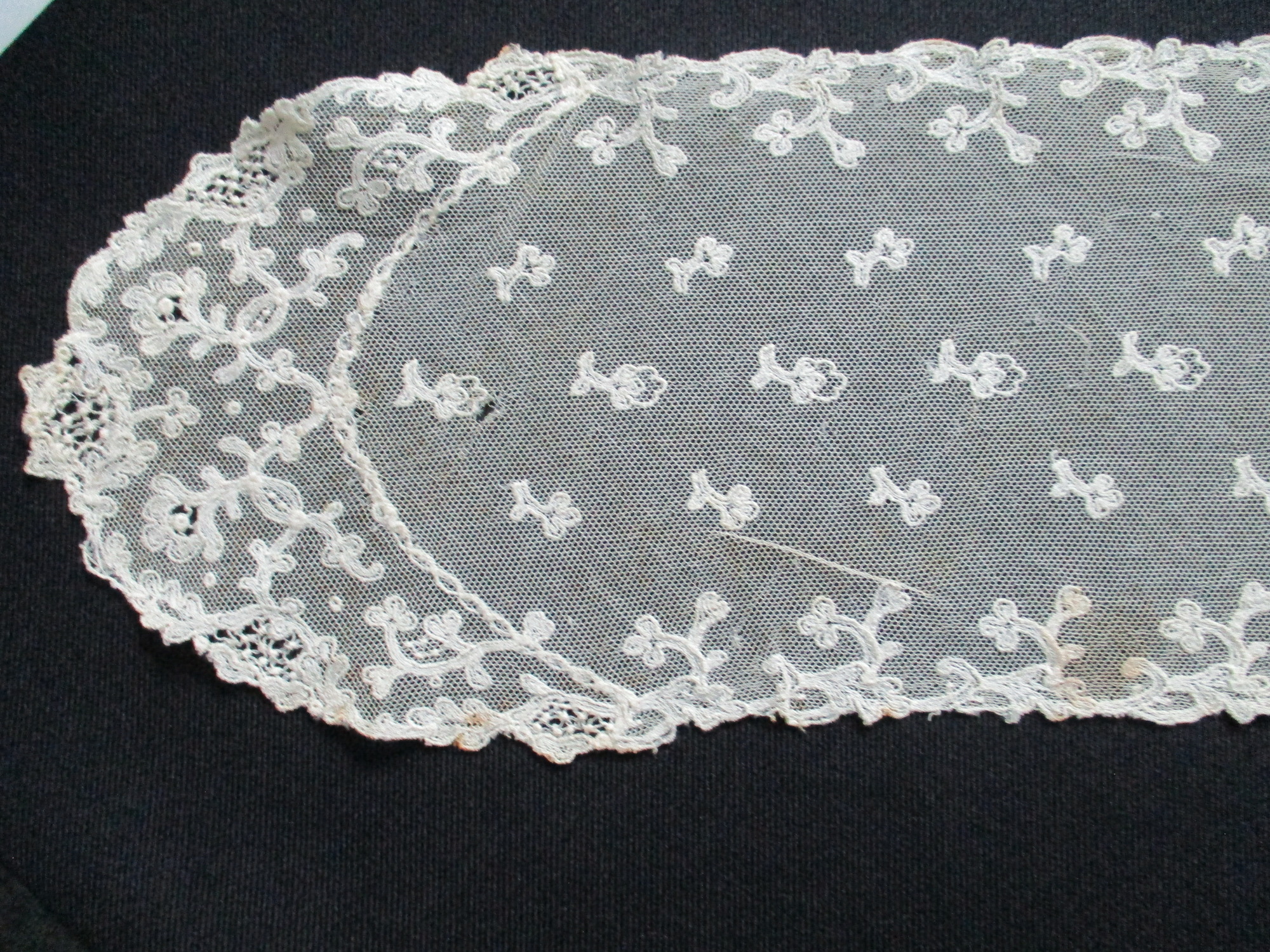 Cream lace sash.: End detail of cream lace sash.