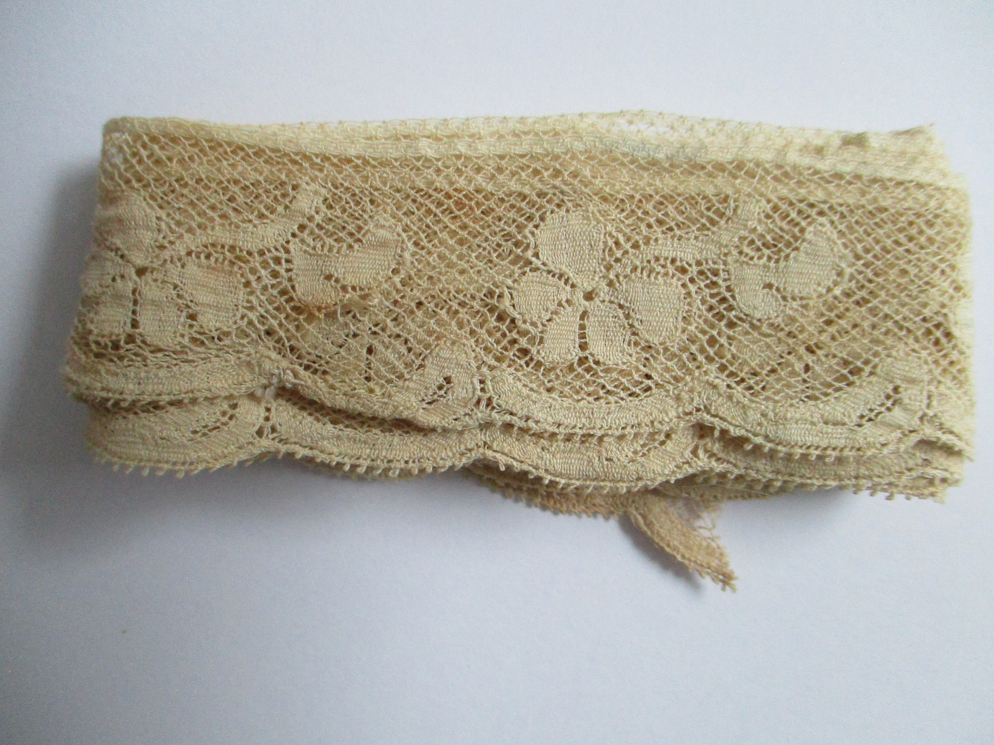 Length of folded silk lace trim.