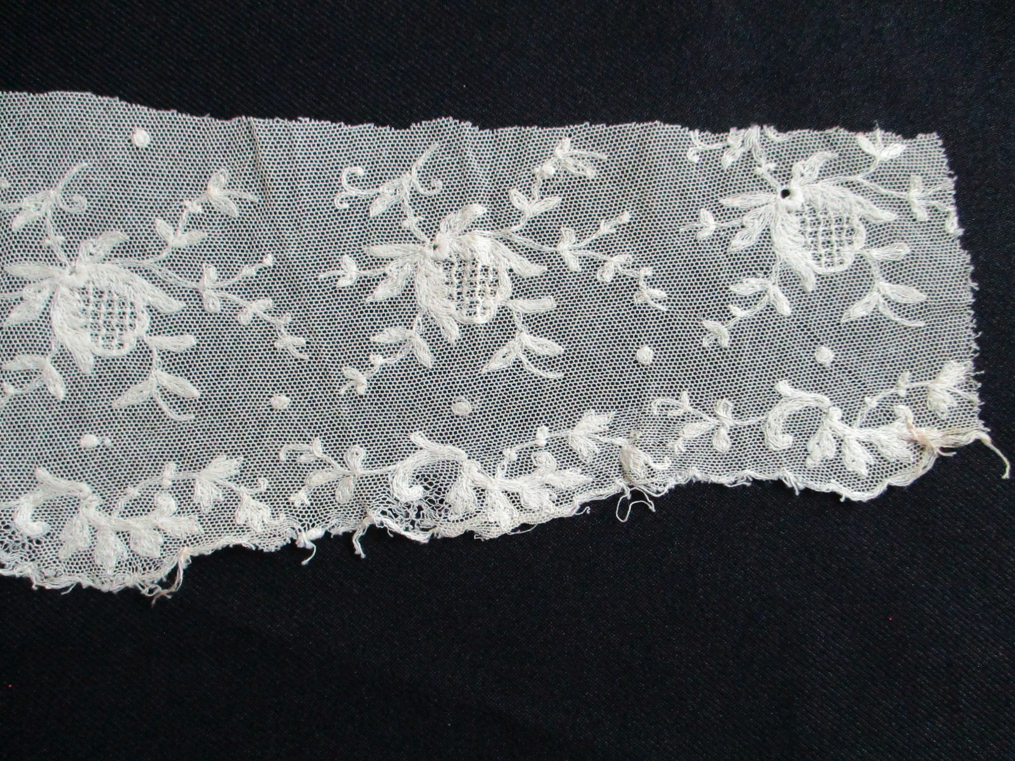Piece of cream silk embroidered netting.: Close up of lace netting showing embroidered design. (i)