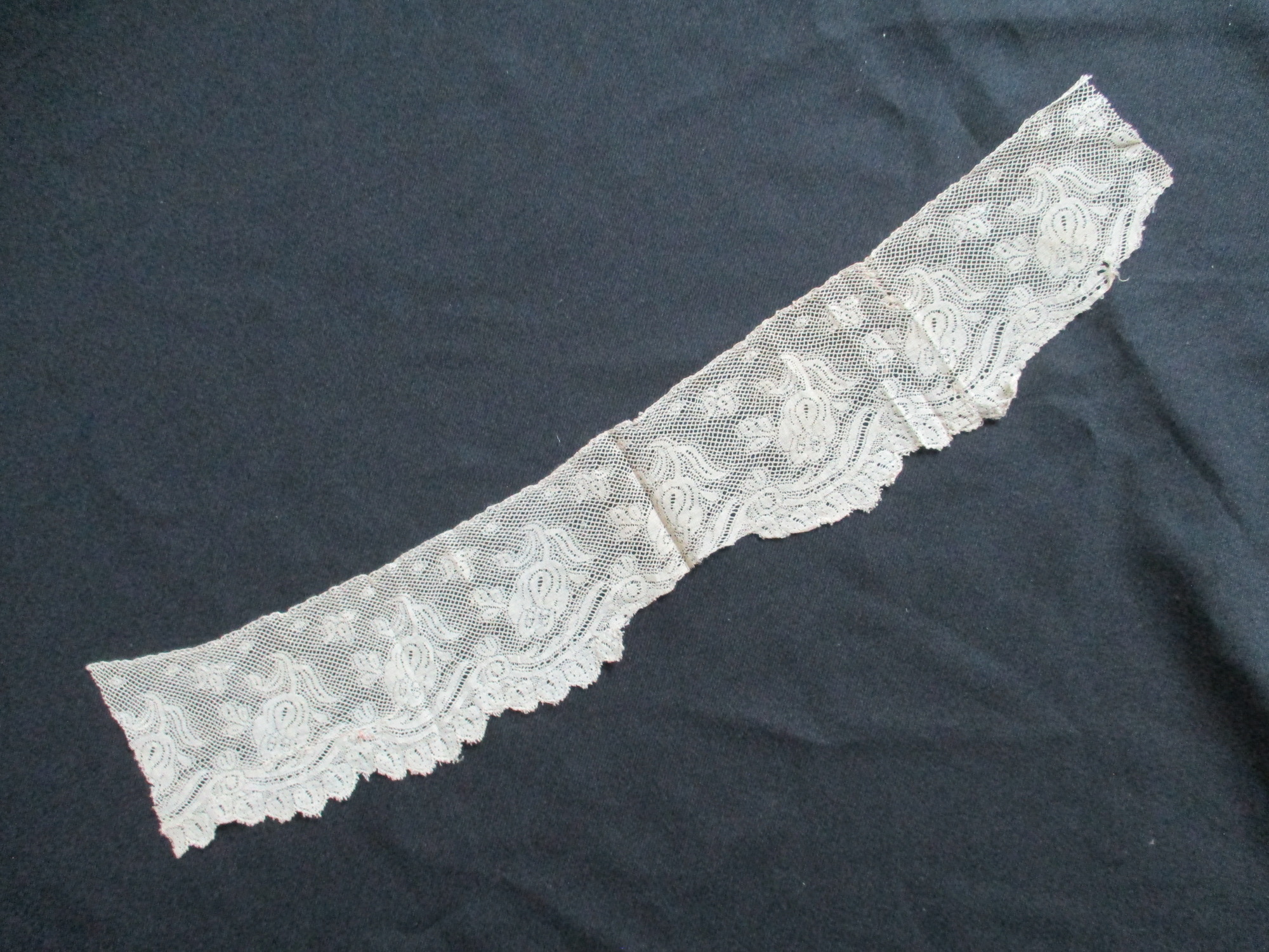 Piece of cream silk lace edging.