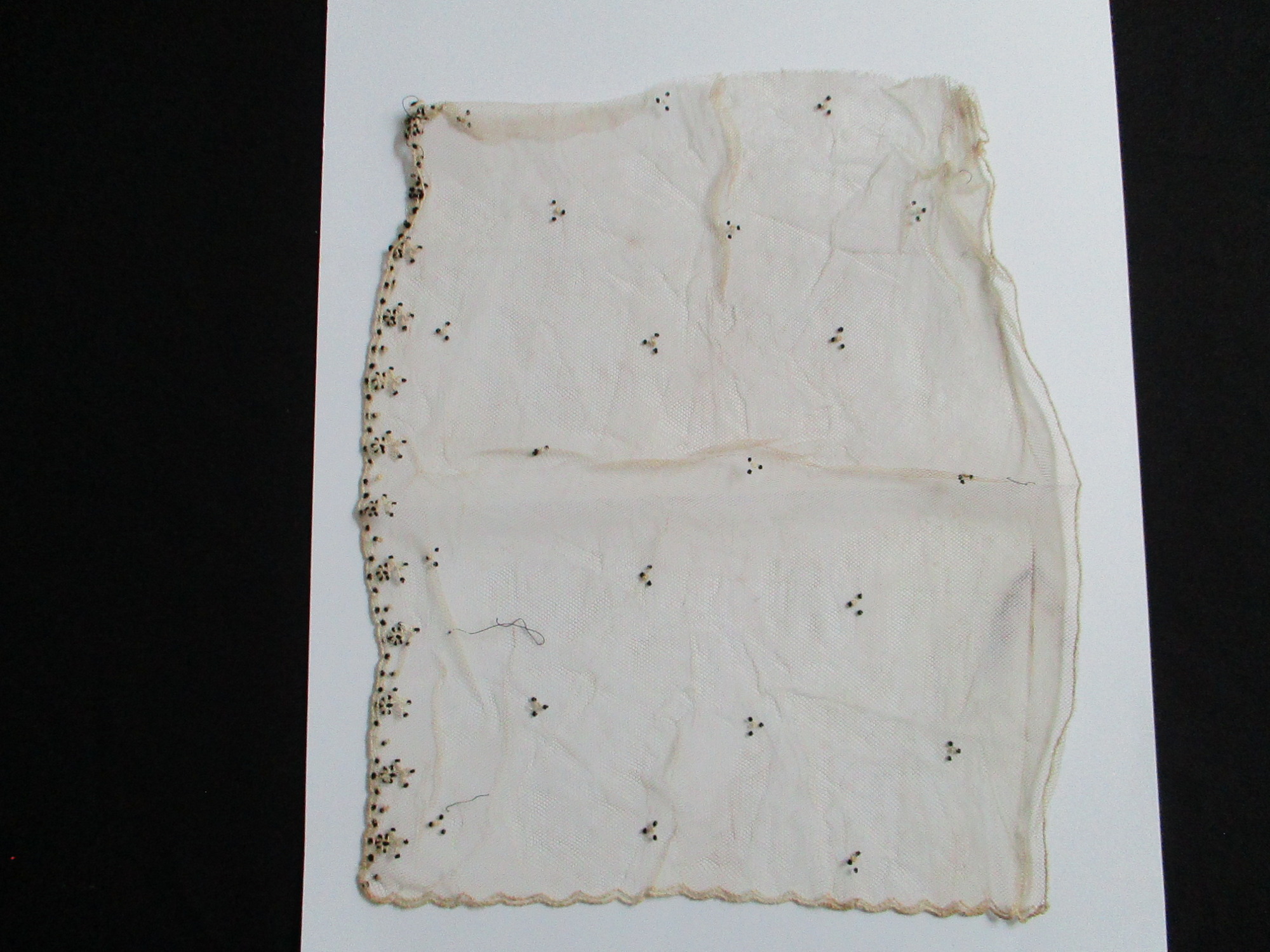 Piece of decorated cream netting.