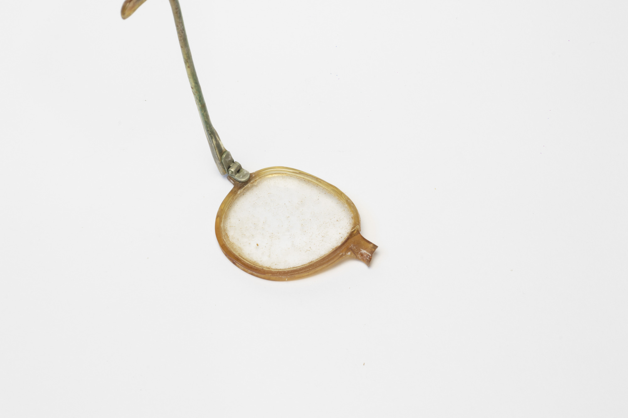 Spectacles: Left hand lens, rear view, arm raised