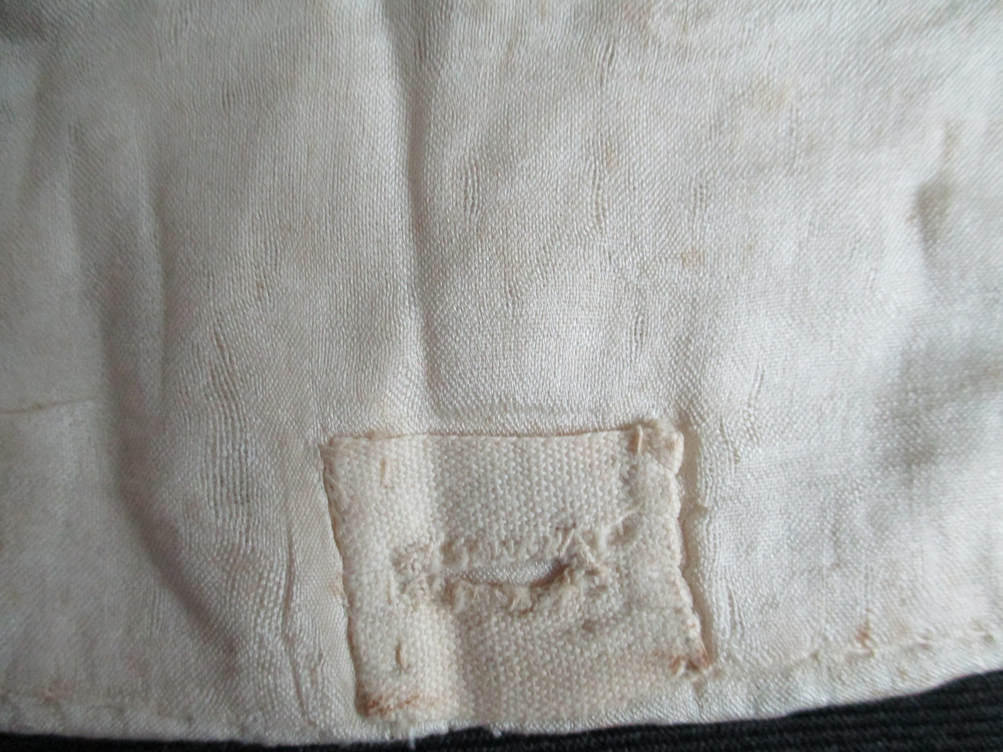 Two part collar: Buttonhole detail on silk collar liner.