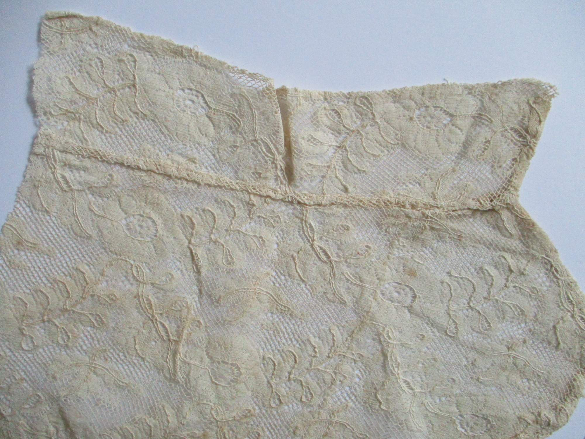 Two pieces of cream silk lace.: Design detail on cream silk lace cut from collar/bib. (ii)