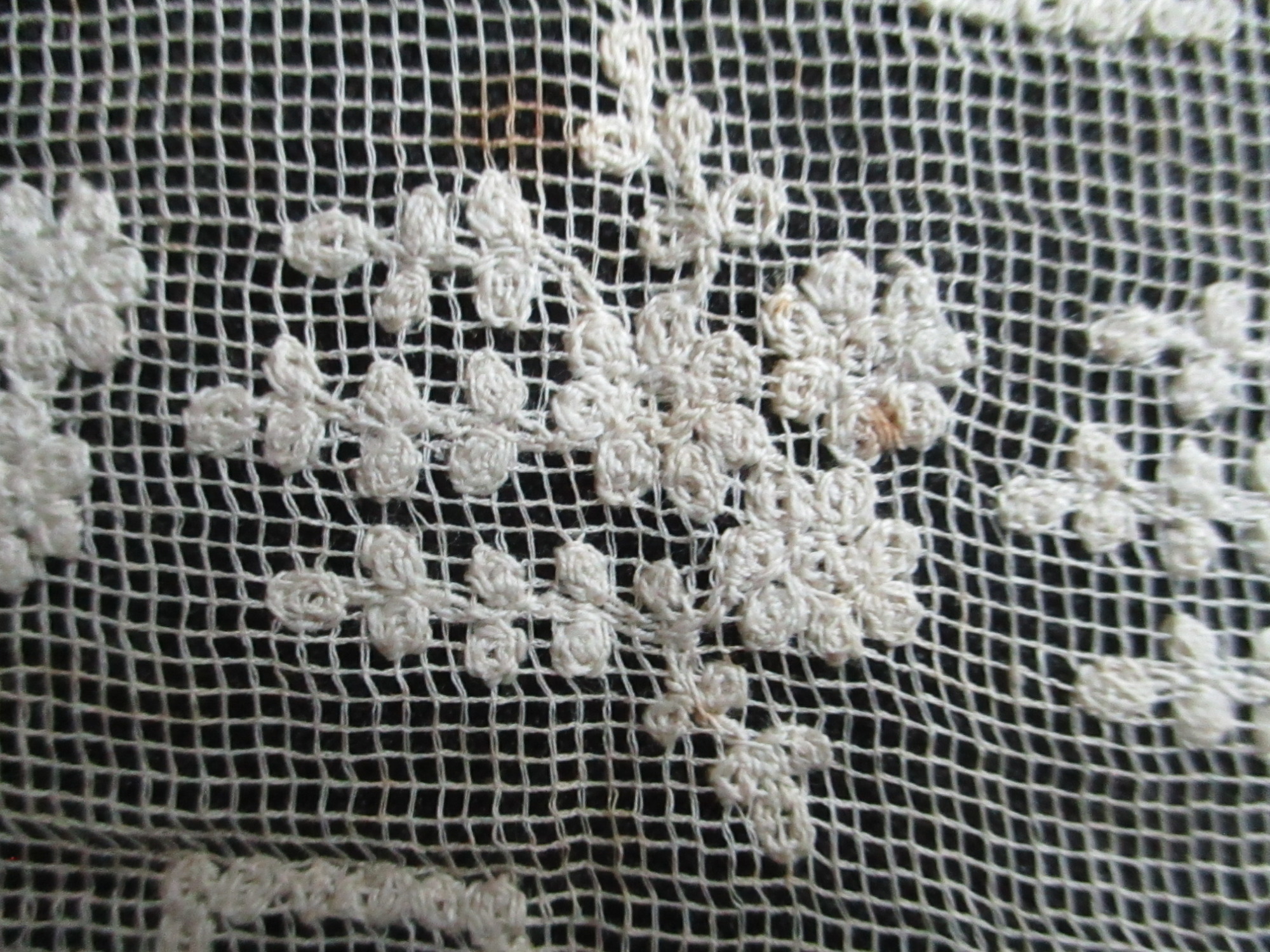 Two pieces of decorated cream netting.: Embroidered detail on cream lace ribbon pieces.